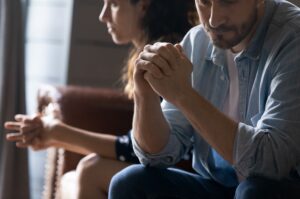 A couple after arguing sitting apart from each other. 