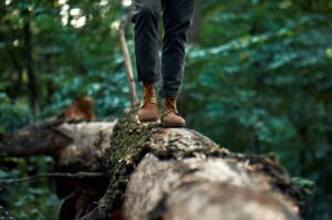 A man walking on a log. 