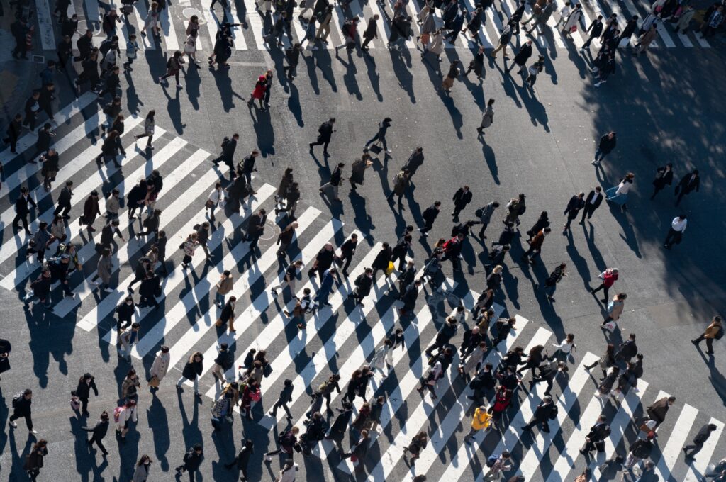 A crowd of people crossing a road.